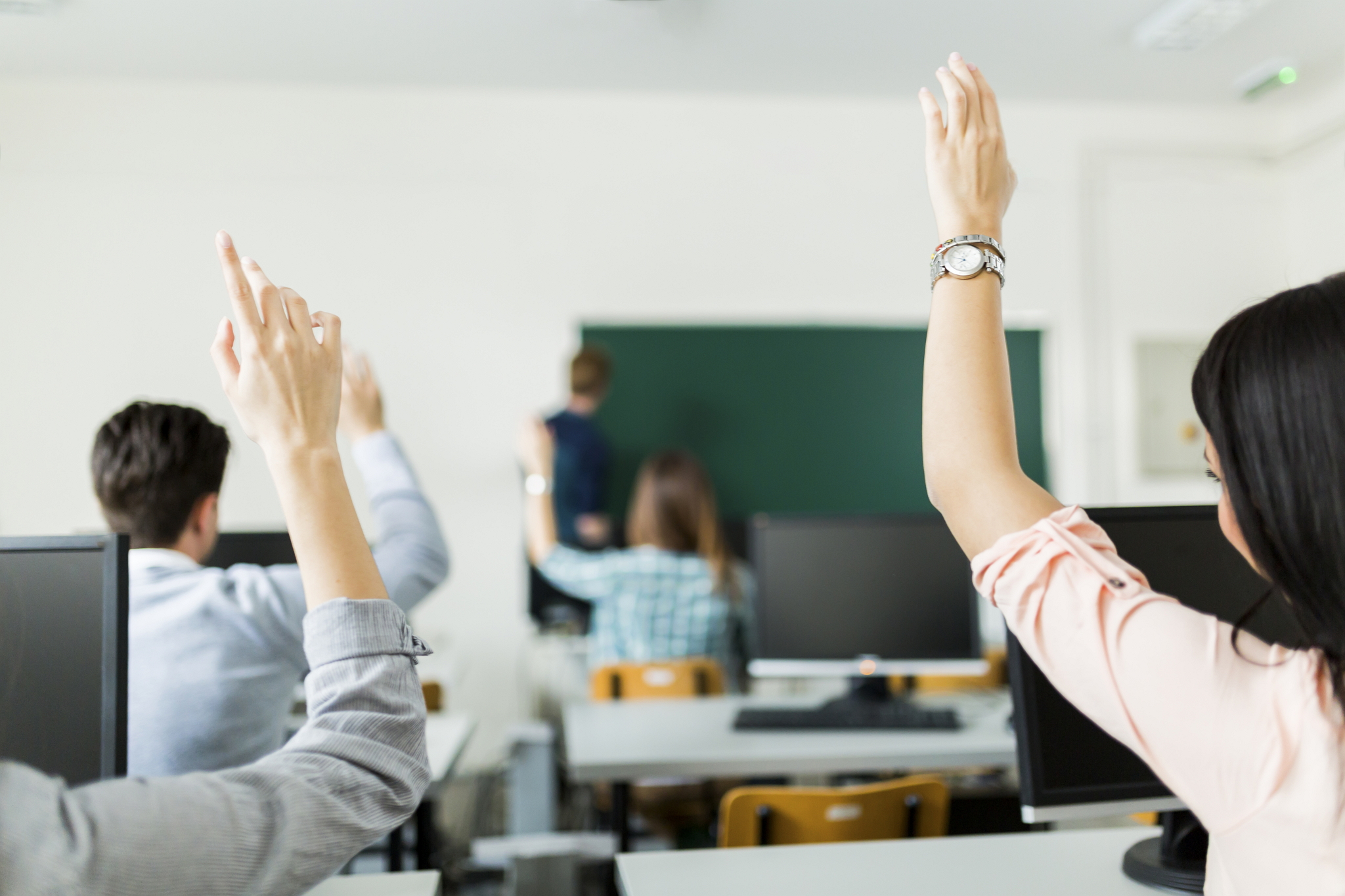 Young Students Raising Hands In A Classroom See How Support